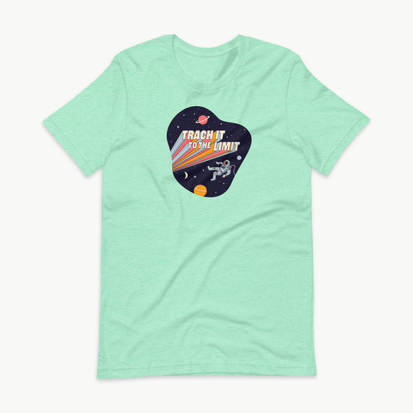 An illustration of an astronaut with a trach and tubing floating in outer space surrounded by stars and planets. Behind the astronaut, bold retro text reads “Trach It to the Limit,” with colorful light trails shooting from the words like a rocket launch. The design appears on a dark background. It is on a heather mint adult t-shirt.