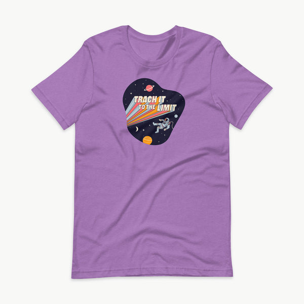 An illustration of an astronaut with a trach and tubing floating in outer space surrounded by stars and planets. Behind the astronaut, bold retro text reads “Trach It to the Limit,” with colorful light trails shooting from the words like a rocket launch. The design appears on a dark background. It is on a purple adult t-shirt.